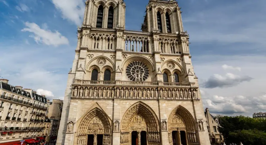 La fachada de Notre Dame, con sus torres gemelas y rosetón, se alza majestuosa. Hoy se puede visitar Notre Dame, un icono de París lleno de historia.