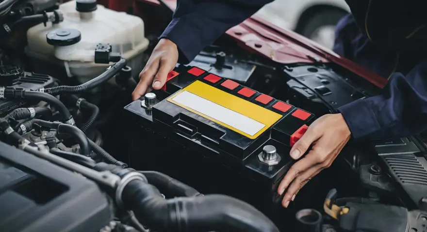 Mechaniker tauscht Batterie aus, da die Lichtmaschine defekt oder die Batterie leer ist.