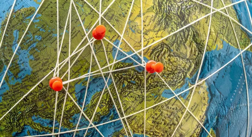 Marzenia o podróżach do Mozambiku? Mapa świata z zaznaczonymi trasami i pineskami symbolizuje plany na wakacje.