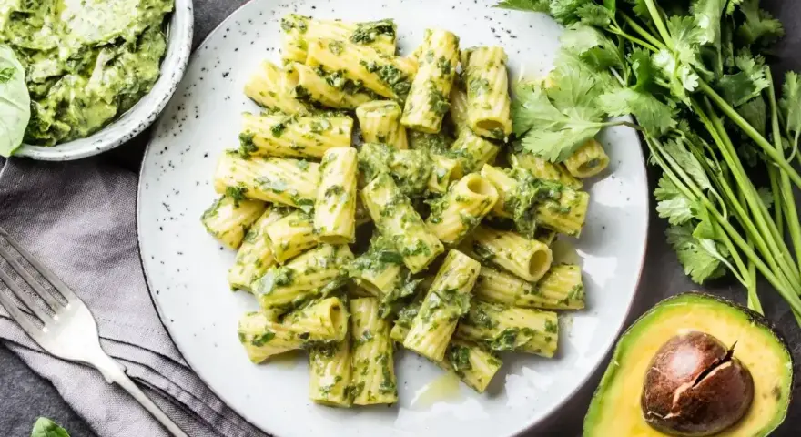 Pyszny makaron z pesto bazyliowym, podany z awokado i świeżymi ziołami. Idealny na lekki obiad.