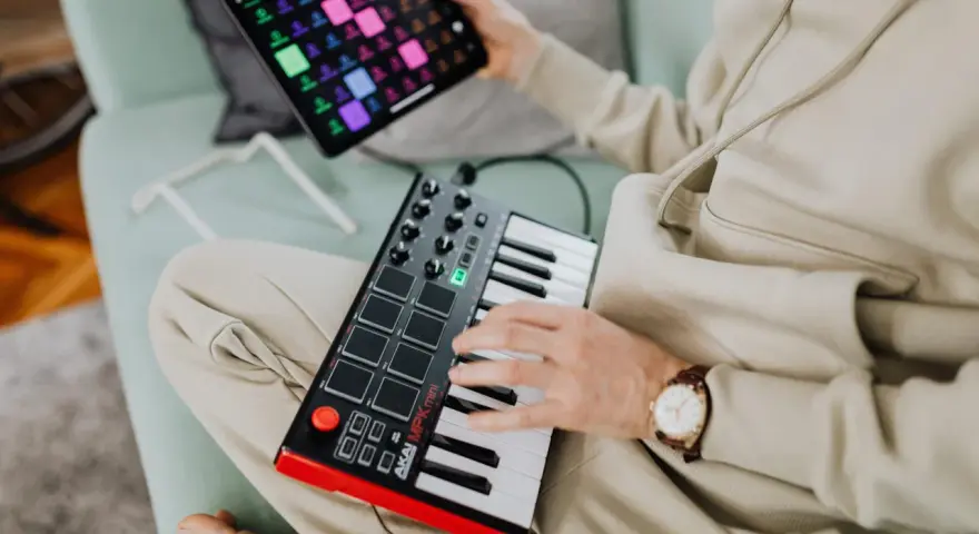 Osoba tworzy muzykę na kontrolerze midi usb. To świetny sposób na rozpoczęcie przygody z produkcją muzyczną.