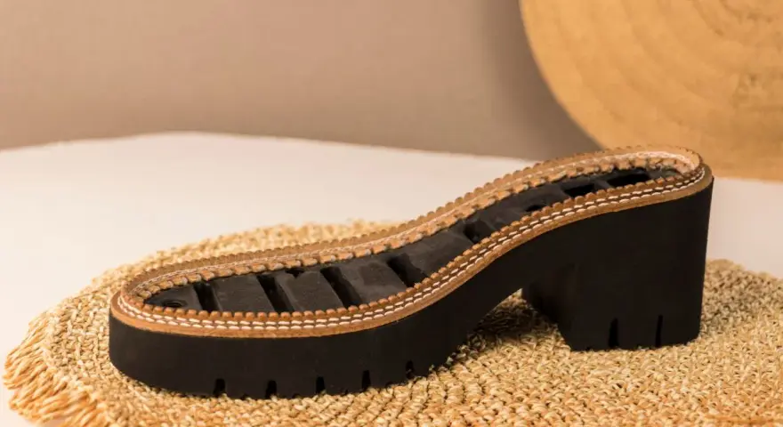 Suela de zapato con plataforma y tacón grueso, elaborada con caucho natural y detalles de cuero.