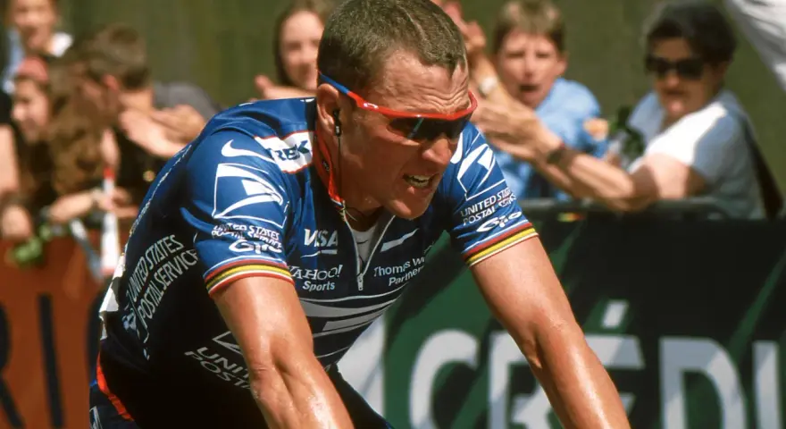 Lance Armstrong, in his USPS jersey, strains during a race, a stark image given how Lance Armstrong cheated his way to victory.