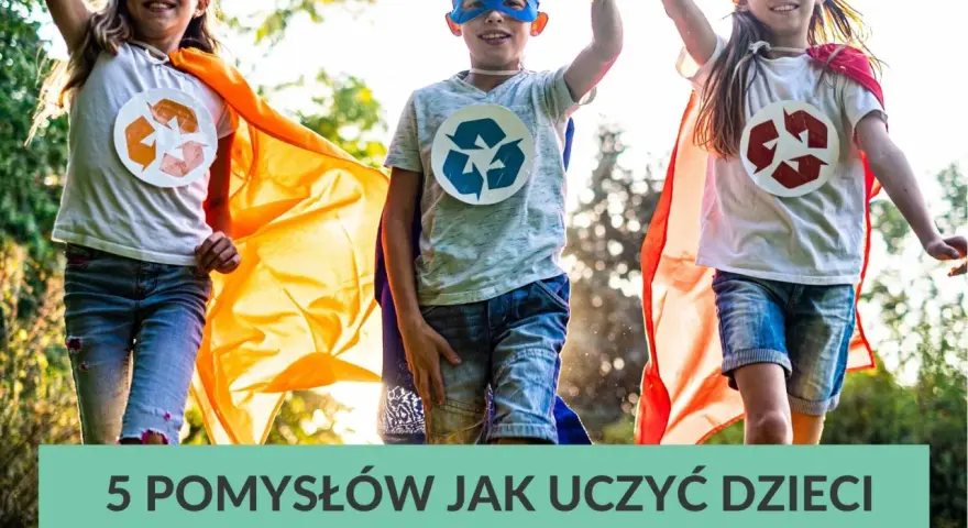 Trójka dzieci w pelerynach i maskach superbohaterów, z symbolami recyklingu na koszulkach, biegnie przez trawnik. Uczą się ekologii!