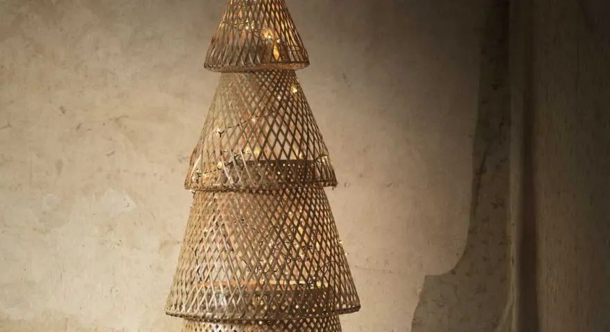 Un sapin de Noël en tissu à faire soi-même, fait de cônes tressés et illuminé de guirlandes lumineuses.