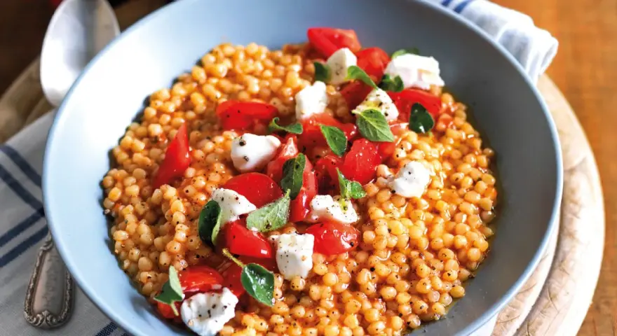 Fregola con pomodorini freschi, mozzarella e basilico. Un piatto colorato e gustoso, perfetto per le tue fregola ricette semplici.