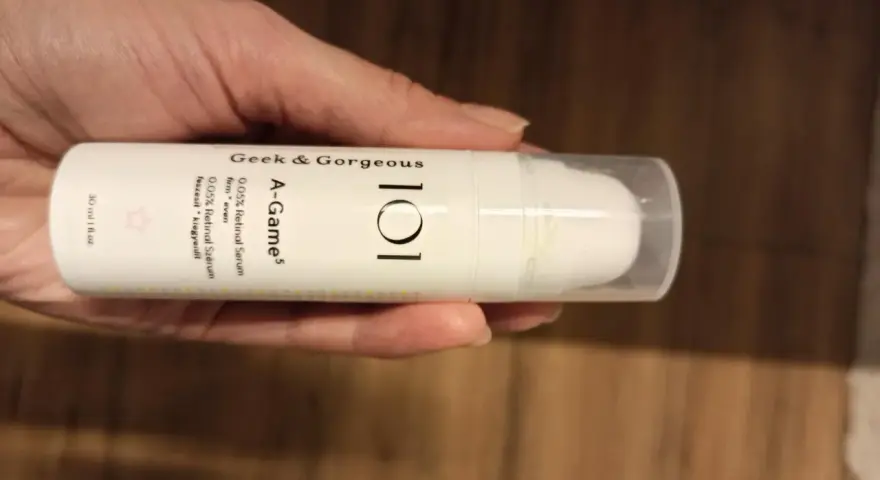 Dłoń trzyma serum Geek & Gorgeous A-Game 0.05% Retinal. Skóra wygląda na nawilżoną i promienną.