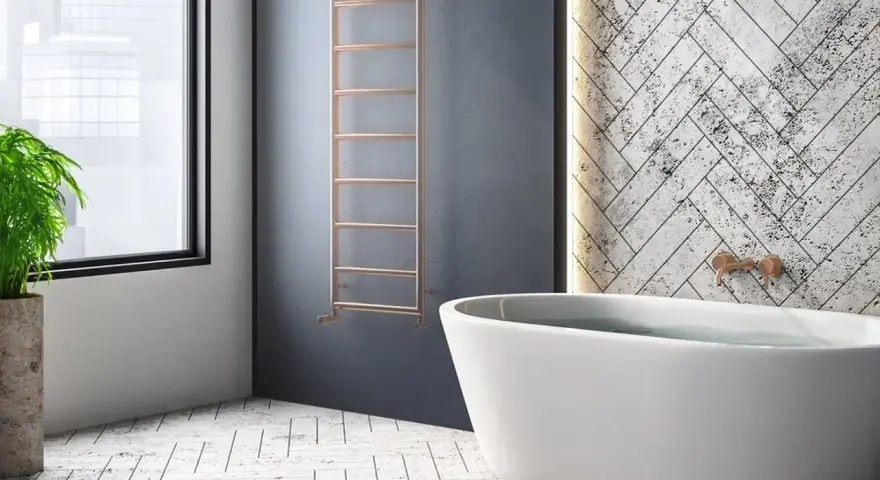 Radiador de agua vertical de cobre, un ejemplo de tipos de radiadores de agua, junto a una bañera y una planta.