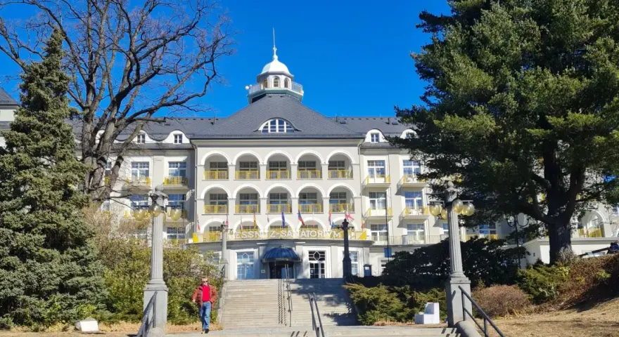 Piękny budynek sanatorium w Jesenikach w Czechach, z charakterystycznymi arkadami i żółtymi balkonami.