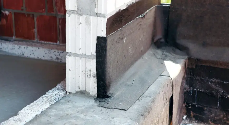 Papa do izolacji poziomej na styku ścian z bloczków i fundamentu. Zabezpieczenie przed wilgocią.