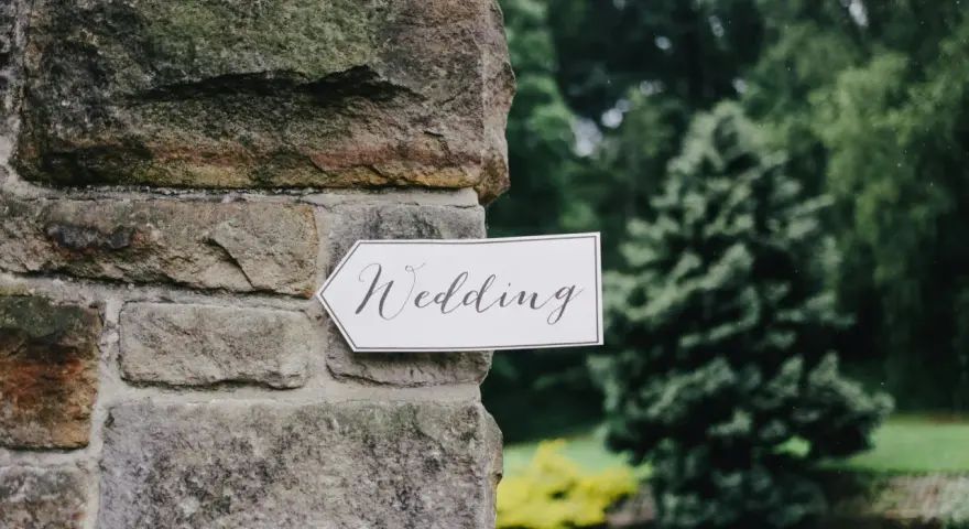 Strzałka z napisem "Wedding" wskazuje drogę do uroczystości, zapowiadając tradycyjny marsz weselny.