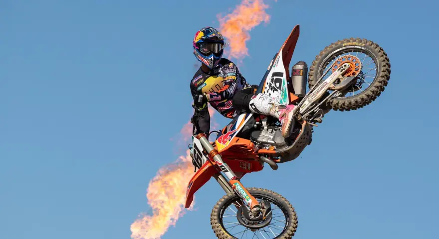 Motociclista Jorge Prado en el aire con llamas saliendo de su moto.