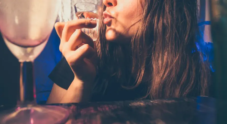 Młoda osoba pije alkohol. Pamiętaj, co grozi za picie alkoholu w wieku 17 lat: problemy zdrowotne i prawne.