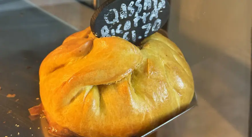 Złociste, pieczone ciasto z nadzieniem, typowe maltańskie jedzenie. Na tabliczce napis "Cassata Ricotta €1.70".