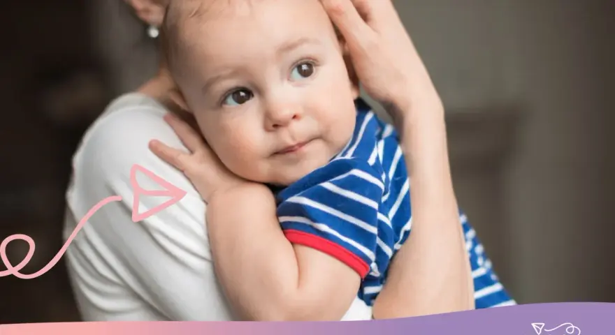 Ciepły uścisk mamy, kiedy dziecko zaczyna się przytulać. Maluch w pasiastym ubranku wtula się w nią z ufnością.