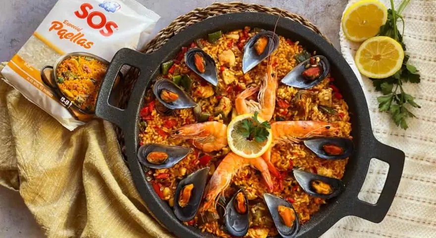 Paella mixta en paellera con gambas, mejillones, limón y bolsa de arroz SOS.