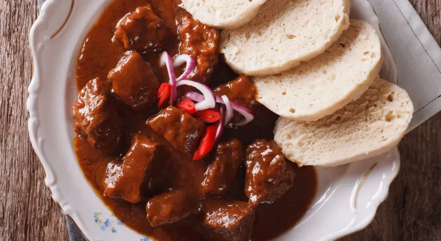 Stracotto toscano succulento in salsa ricca, servito con fette di pane soffice. Un piatto che sa di tradizione.