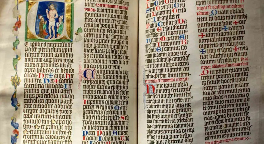 First Sunday of Advent readings from an illuminated manuscript. Jesus is depicted in the initial letter, with ornate borders and calligraphy.