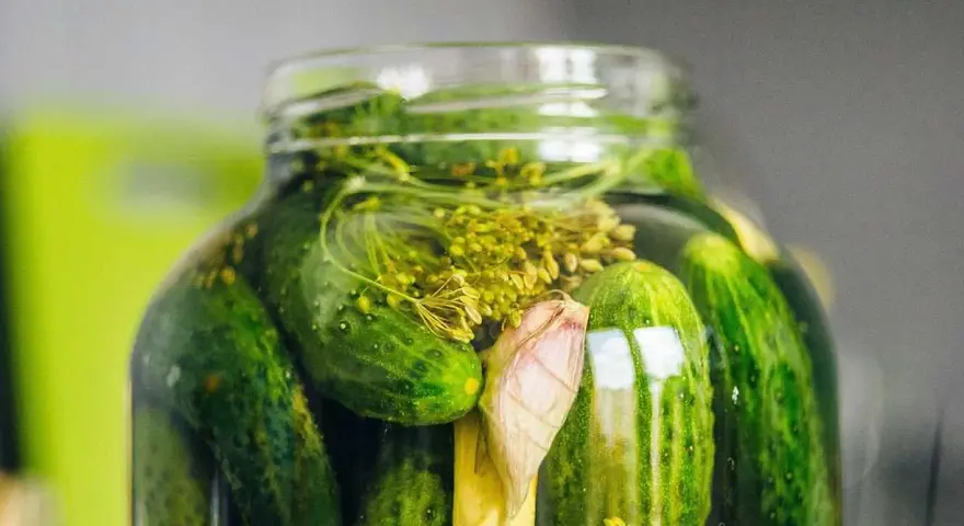 En burk med inlagda gurkor, dill och vitlök. Perfekt för ett gott saltgurka recept.