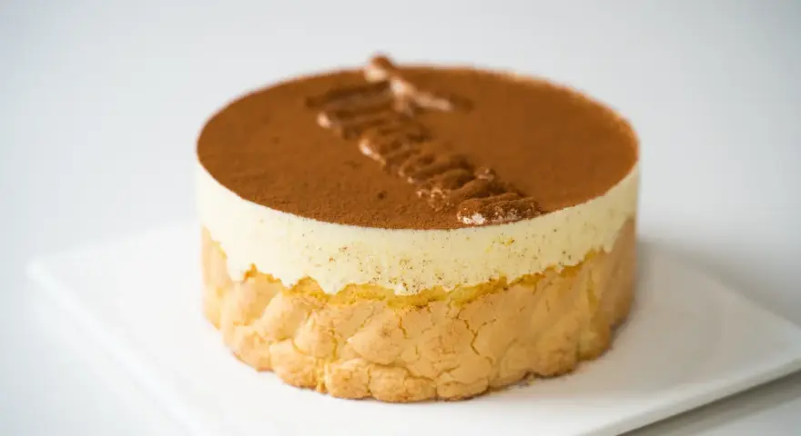 Pyszne tiramisu czekoladowe, udekorowane kakao i kremem. Idealne na deser.