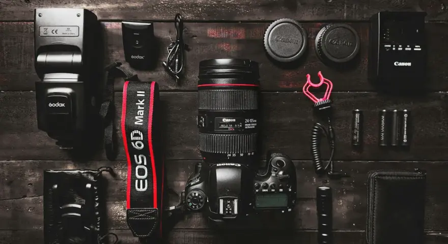 Zestaw do fotografii: aparat Canon EOS 6D Mark II, obiektyw, lampa błyskowa, baterie i akcesoria. Idealny zestaw, jeśli zastanawiasz się, jaki aparat na początek.