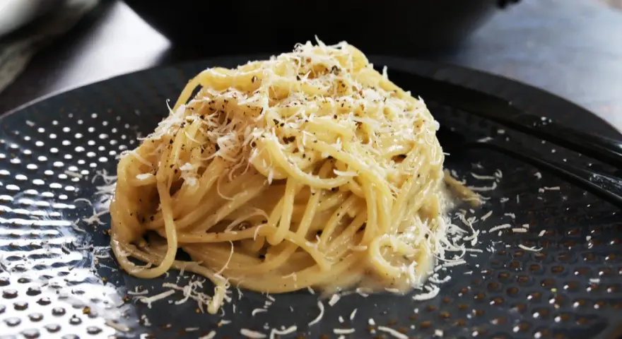 Pyszne spaghetti Cacio e Pepe, posypane startym parmezanem i świeżo mielonym pieprzem. Idealne na szybki obiad.