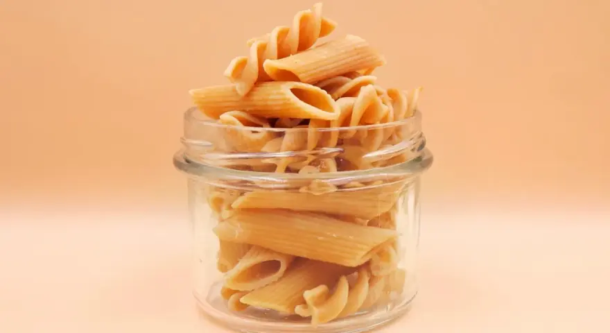 Słoik pełen makaronu penne i fusilli. Zastanawiasz się, ile czasu gotować makaron, by był idealny?