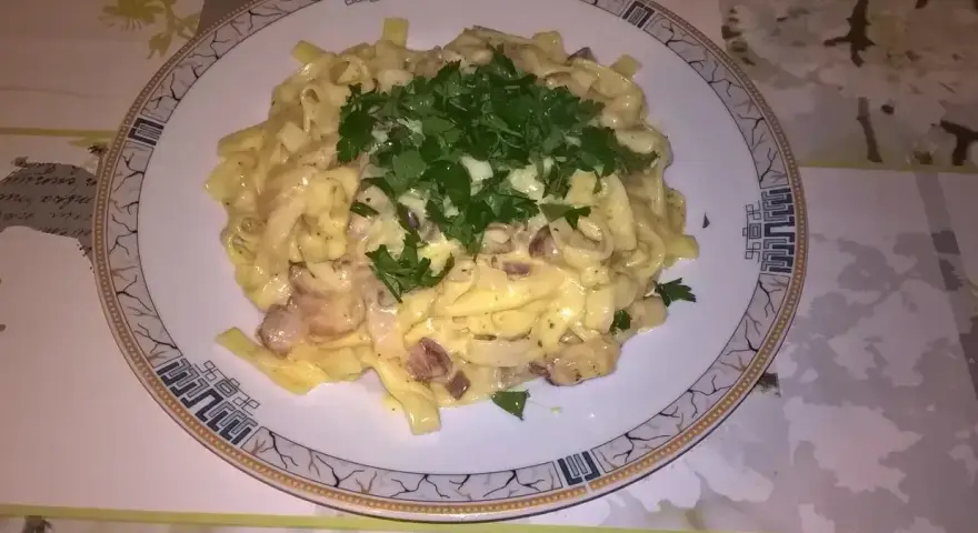 Pyszne fettuccine z boczkiem i pieczarkami, polane kremowym sosem. Idealna odpowiedź na pytanie: jaka śmietana do carbonary?