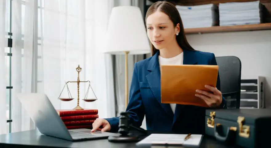 Prawniczka pracuje nad sprawą wdrożenie windykacji, analizując dokumenty na laptopie.