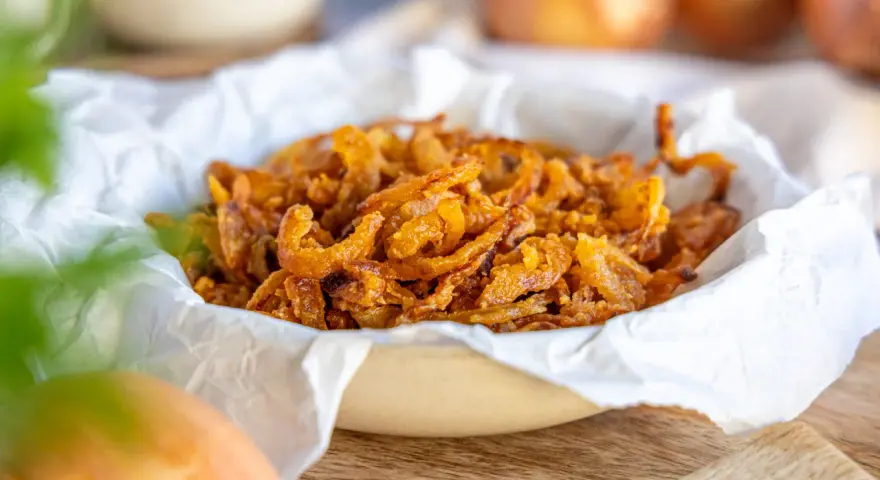 Knusprige frittierte Zwiebelringe in einer Schüssel, bereit zum Genießen.