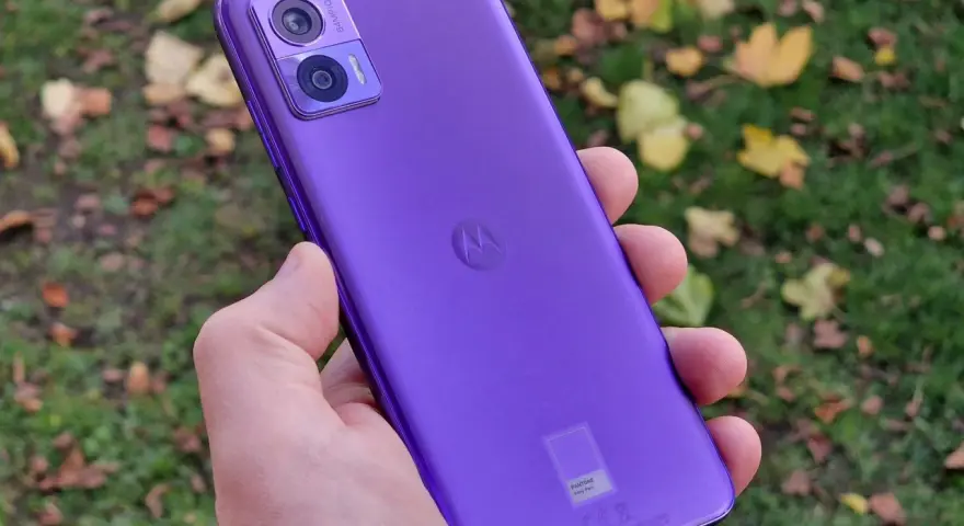 Fioletowy Motorola Edge 30 Neo Play w dłoni, na tle jesiennych liści. Idealny do uchwycenia każdej chwili.
