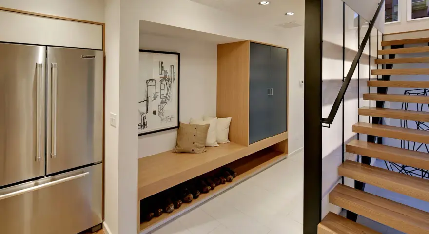 Ideas para decorar un pasillo interior: un banco de madera con almacenamiento, cuadros y una escalera moderna.