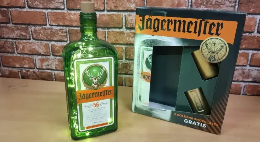 Butelka Jägermeistera z lampkami LED i zestawem dwóch złotych kieliszków. Idealne do prostych drinków z Jägermeister.