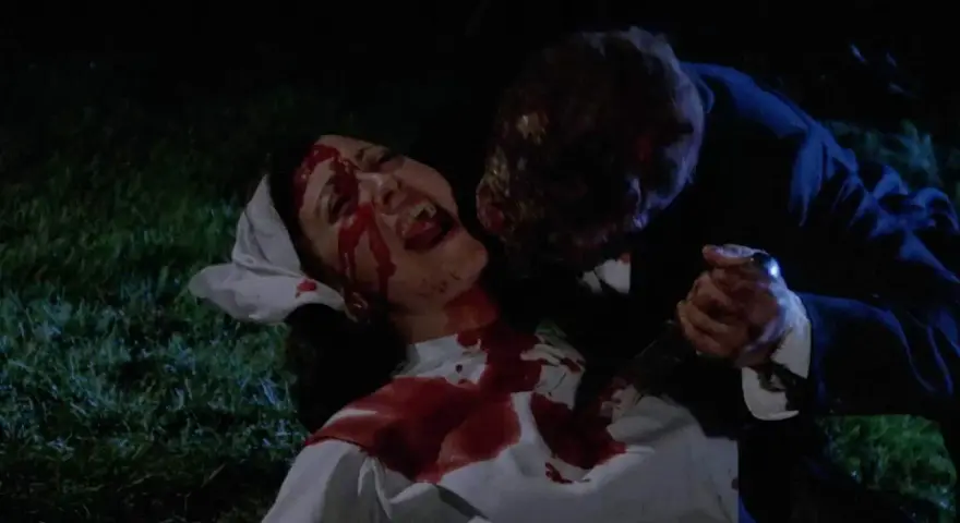 Una vittima urlante, coperta di sangue, viene attaccata da una figura grottesca con un coltello. Un'immagine raccapricciante che evoca un **horror cult**.