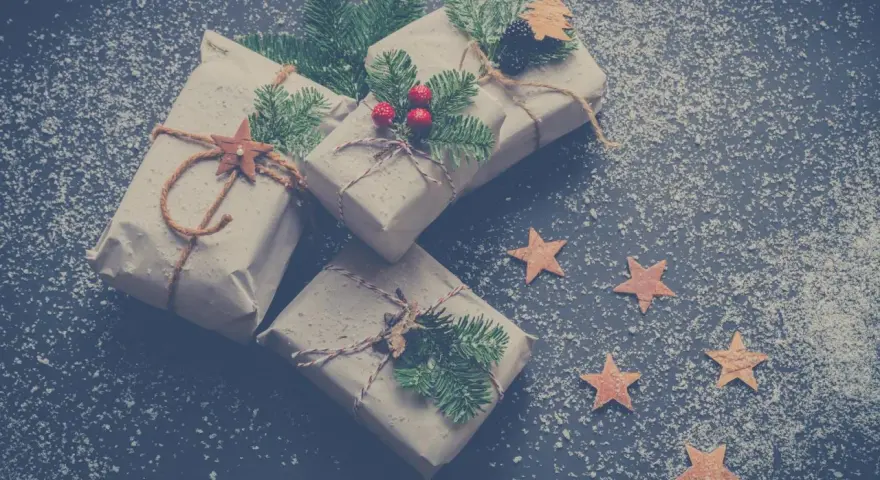 Julklappar inslagna i brunt papper med granris och stjärnor. Perfekta julkort idéer för en mysig julkänsla.