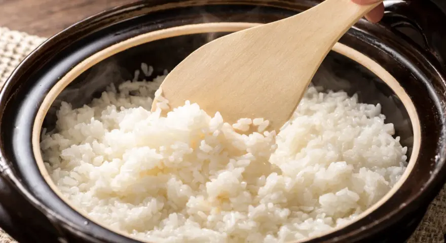 Arroz blanco recién cocido, humeante y esponjoso, listo para servir. Explora los diferentes tipos de arroz y sus texturas.