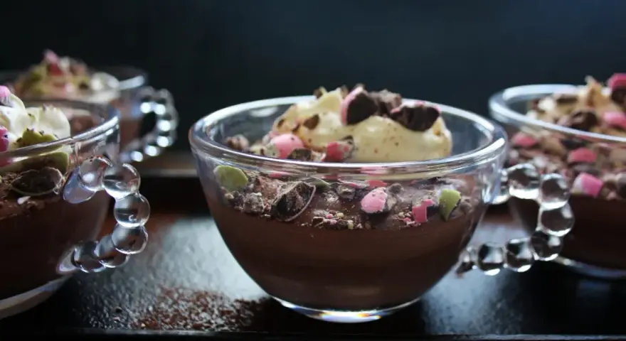 Chokladmousse recept i små glasbägare, toppad med grädde och krossad choklad. En perfekt dessert!