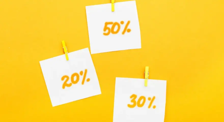Trzy karteczki z napisami 20%, 30% i 50% przyczepione żółtymi spinaczami. Idealne zniżki dla emerytów!