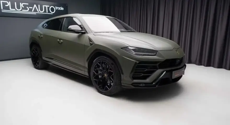 Matowy, zielony Lambo Urus z czarnymi felgami stoi w studiu.