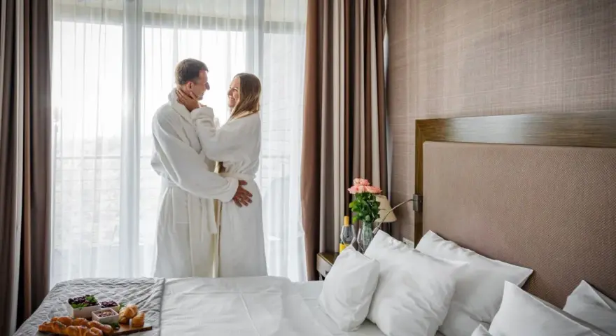 Para spędza romantyczny poranek w szlafrokach, delektując się śniadaniem. Idealny spa nad morzem dla dwojga.