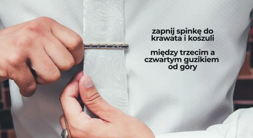Mężczyzna zapina spinkę do krawata i koszuli między trzecim a czwartym guzikiem od góry. Elegancki dodatek, który podkreśla styl.