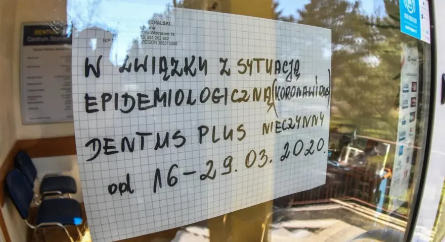 Kartka na szybie z napisem "Dentus Plus nieczynny od 16-29.03.2020" z powodu sytuacji epidemiologicznej.