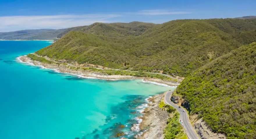 La Great Ocean Road, un must per chi cerca cosa vedere in Australia, serpeggia tra montagne verdi e acque turchesi.