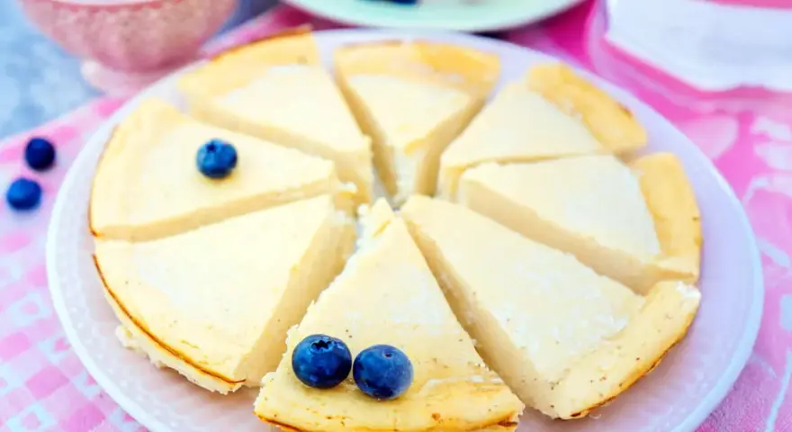 Ein köstlicher low carb Kuchen, in Stücke geschnitten und mit Blaubeeren garniert, wartet auf Genuss.