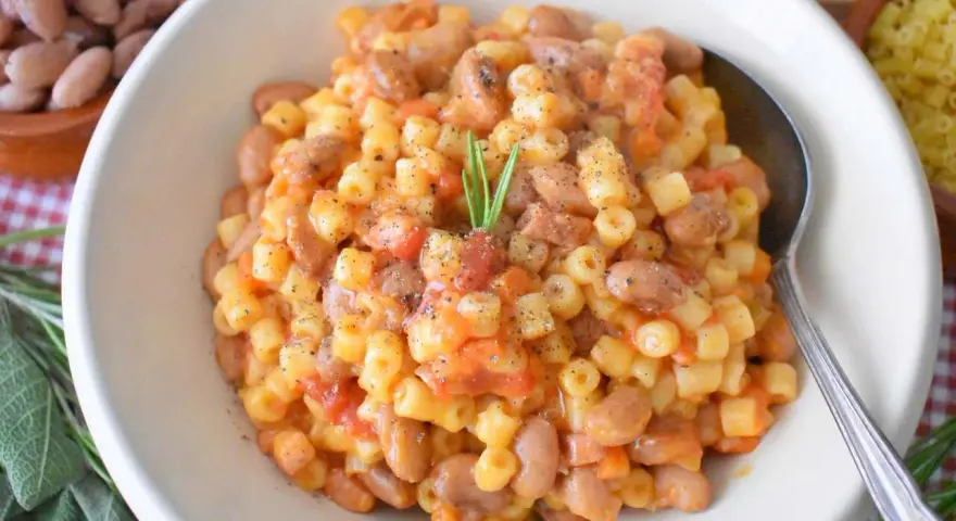 Pyszne danie Pasta e Fagioli przepis. Makaron z fasolą i pomidorami, doprawione pieprzem i gałązką rozmarynu.