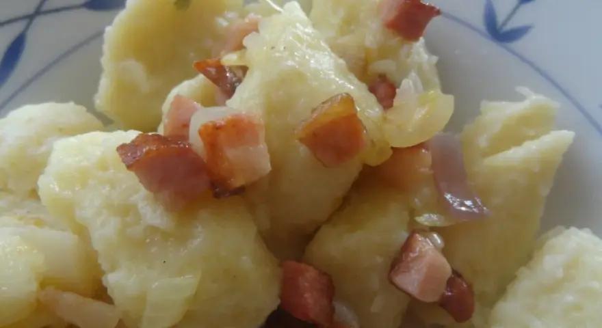 Kopytka z sosem i skwarkami z boczku, pyszne danie.