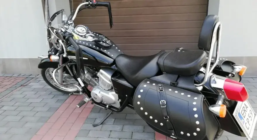 Czarny motocykl Honda Shadow z sakwami i oparciem. Zastanawiasz się, jaki silnik wybrać do tej maszyny?