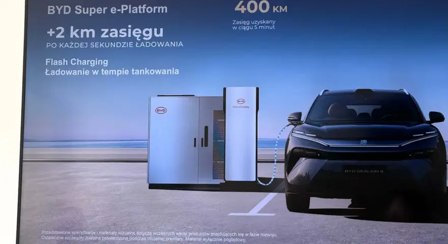Czarny samochód elektryczny BYD Sealion 8 podłączony do stacji ładowania Flash Charging.