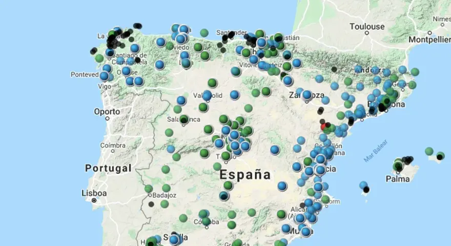 Mapa de España con puntos de colores que indican niveles de contaminacion atmosferica.