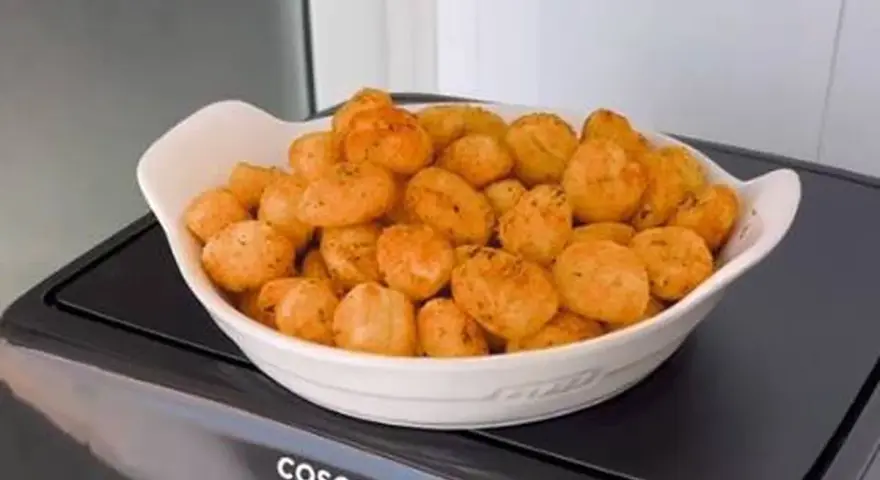 Ñoquis dorados y crujientes en una fuente blanca, recién salidos de la freidora de aire Cosori. ¡Perfectos para picar!